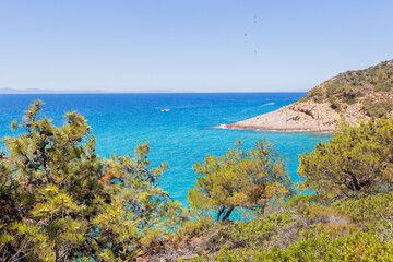 Stunning view of the Greek coastline, featuring vibrant turquoise waters and a sunny summer holiday vibe.