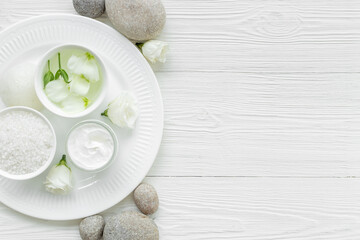 White roses and stones with skin care cosmetics products. Mock up, top view