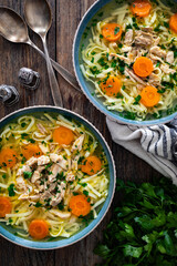 Broth - chicken soup with vegetables on wooden table
