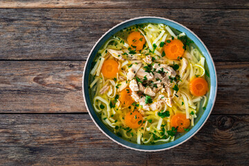 Broth - chicken soup with vegetables on wooden table
