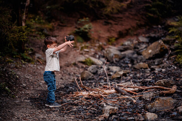 Young Boy Playing with Rocks in Forested Area