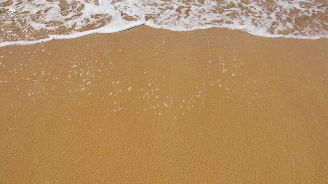 Wave and sea foam on the sand