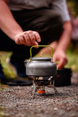 Kettle Heating on Portable Camping Stove in Outdoor Setting