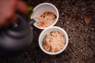 Pouring Hot Water into Instant Noodle Cups Outdoors
