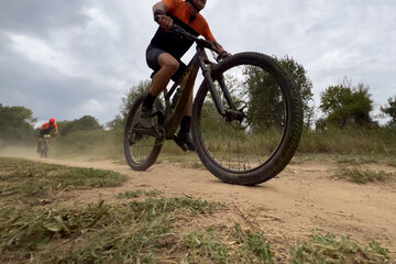 athlete riding mountain bike on dusty trail in cross country race