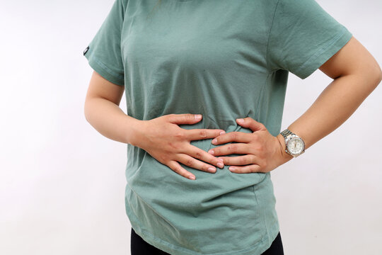 Close up phone of woman's hand holding right stomach, suffering from stomach pain in the left side. Isolated on white