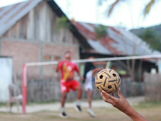 closeup of a man hand holding a takraw ball 