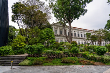 "Fort Canning Park" sign in front of Singapore National Museum building - old colonial building with beautiful plants and trees.