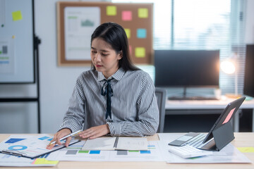 A woman is sitting at a desk with a white board behind her