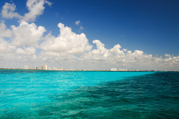 Turquoise waters and blue sky off Isla Mujeres, a serene tropical paradise.