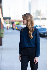 Fototapeta premium Beautiful woman standing on the sidewalk in the city