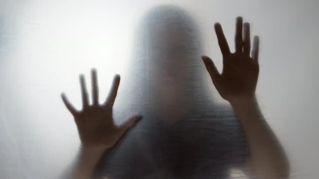 Blurred silhouette of woman and hands asking for help. Concept of violence. Mental health and depression.
