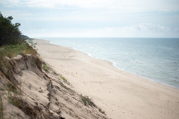 The coastline of the Baltic Sea in northern Poland features stunning sandy beaches, picturesque dunes, and lush greenery, offering a serene escape for nature lovers and beachgoers.