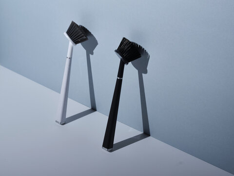Pair of dish brushes leaning against grey wall