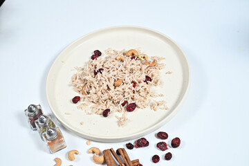 Bowl of rice, nuts, and spices arranged on a wooden table