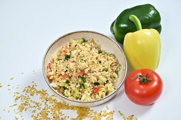 Top view of fresh produce including a ripe tomato, colorful peppers, and a serving of rice