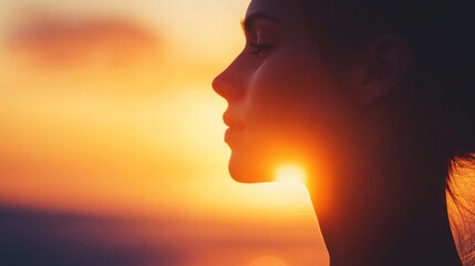 Close-up of a woman silhouette against a sunset, soft light outlining her features, serene and peaceful mood