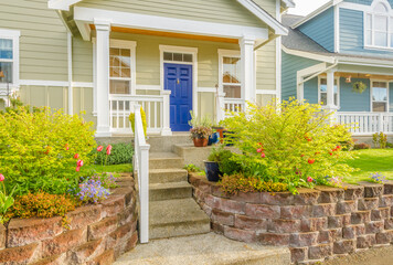 Obraz premium Entrance of grey painted luxury house in summer with stair steps and nice landscape in Vancouver, Canada, North America. Day time on June 2024