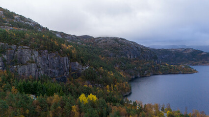 Obraz premium Forested Mountain Landscape with Lake and Cloudy Sky