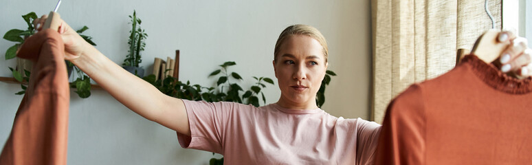 A young woman evaluates clothing options at home, showcasing her style and confidence.