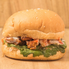 Burger with lettuce and Chicken on a background.
