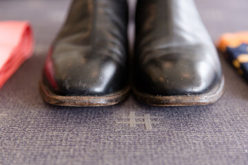 black boots with lightly scuffed toes sitting on grey fabric
