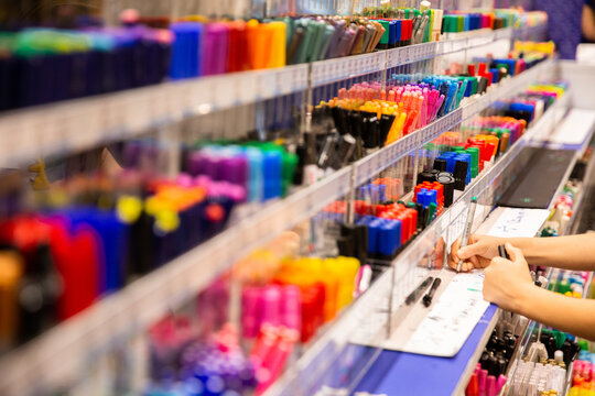 testing out pens for sale at a store that sells stationery