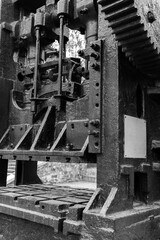 Double-crank press. Massive black gears and other parts