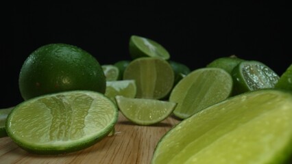 Close-up, a vibrant slice of fresh lime rests upon a rustic wooden cutting board, exuding freshness and vitality. The translucent membranes of the green lime slice placed on cutting board. Comestible.