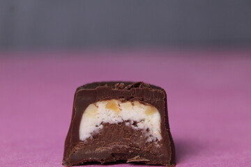 Close-up chocolate candy with chocolate milk filling white brown. The concept of a pastry chef's background