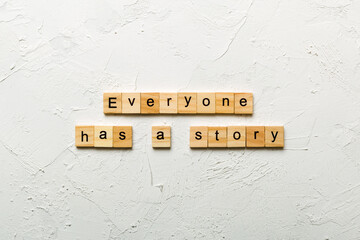 Everyone Has a Story word written on wood block. Everyone Has a Story text on cement table for your...