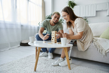 Joyful friends engage in a friendly game while sipping beverages.