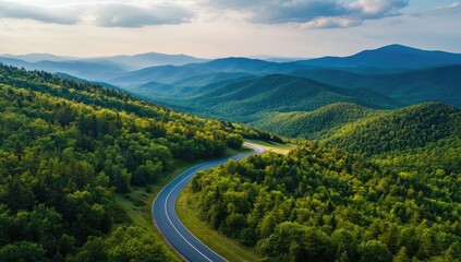 Obraz premium Aerial View of Winding Asphalt Road Through Lush Green Forest and Mountains in Summer, Bird's-Eye Perspective in Europe, Landscape Photography