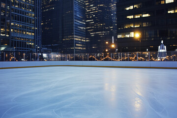 Obraz premium Evening ice skating rink in a cityscape after sunset