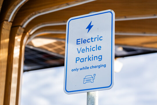 Electric Vehicle parking only while charging sign with solar panels above