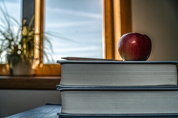 Apple and Books on Desk - A Cozy Study Scene with Natural Light and Warm Tones