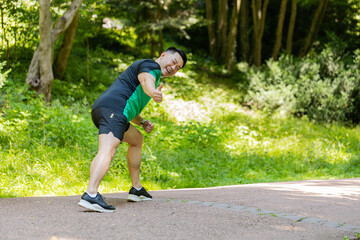 Back view of athletic fitness sport motivated runner guy training marathon run, starting race showing thumbs up. Workout cardio outdoor in park. Young man enjoy jogging. Active Japanese sportsman.