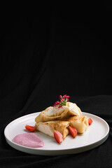 Crepes with Cream Cheese Filling and Strawberries on a White Plate.