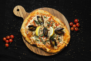 Seafood Pizza with Mussels and Lemon on Wooden Board with Black Background.