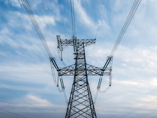 Fototapeta na wymiar High voltage electricity tower and sky cloudscape at sunset