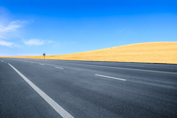 Empty asphalt road and wheat field mountains nature scenery