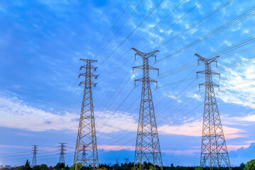 High voltage electricity tower and sky cloudscape at sunset