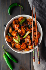 Bowl of Tom Rim (Vietnamese Caramelized Shrimp): Southeast Asian seafood dish with thick sauce, green onions, chili peppers, and chopsticks