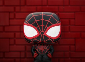 Naklejka premium Tambov, Russian Federation - August 23, 2024 Spider-Man (Earth-1610) Funko POP Mini Vinyl Figure against a red brick wall background.