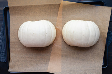 Seeded and Halved White Pumpkin on a Sheet Pan: Halves of a snowball pumpkin rubbed with coconut...