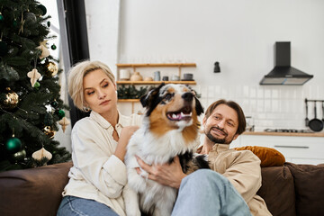 A couple relaxes together on a couch with their dog, embracing the warmth of home.