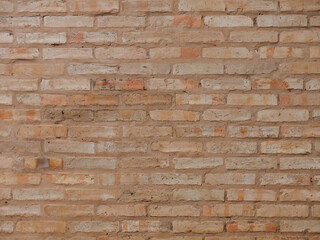 Old weathered sand colored brick wall background for stock photo