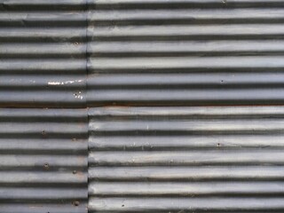Old corrugated sheet metal wall made of several pieces