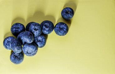 Fresh blueberries on a pastel yellow background create a vibrant, minimalist banner perfect for healthy food themes.