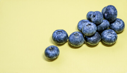 Fresh blueberries on a pastel yellow background create a vibrant, minimalist banner perfect for healthy food themes.